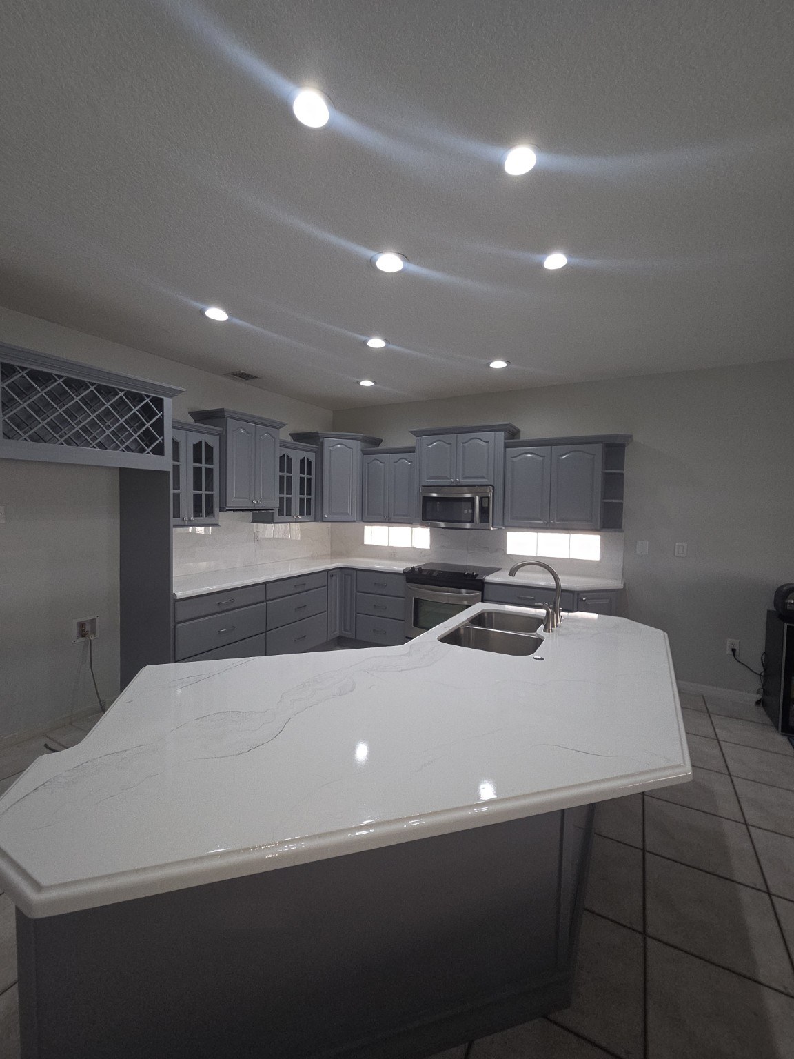 After kitchen with gray cabinets and white epoxy countertop