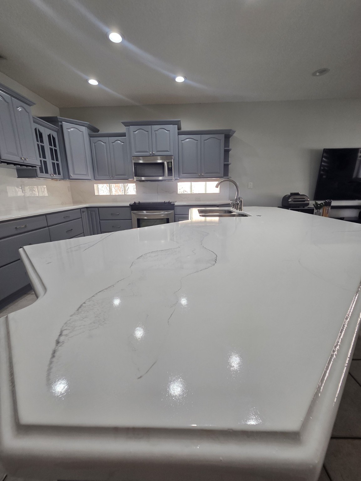 Finished gray kitchen with glossy countertop